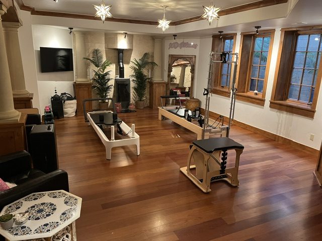 Pilates reformer studio on dark hardwood with star pendant lighting